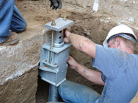 Foundation repair contractors installing the foundation bracket in Sacramento.