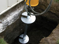 Installing a helical pier system in the earth around a foundation in Fresno